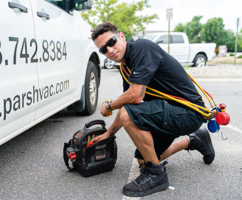Danny from PARS heating & Air Conditioning Kneeling near his work van
