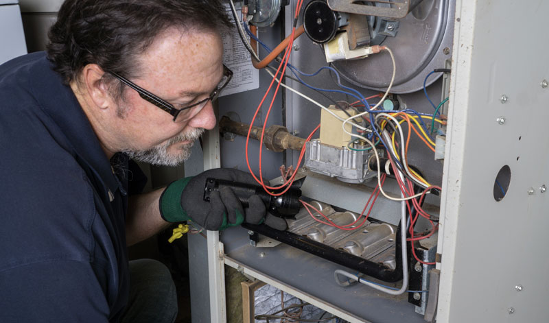 technician performing maintenance on a furnace